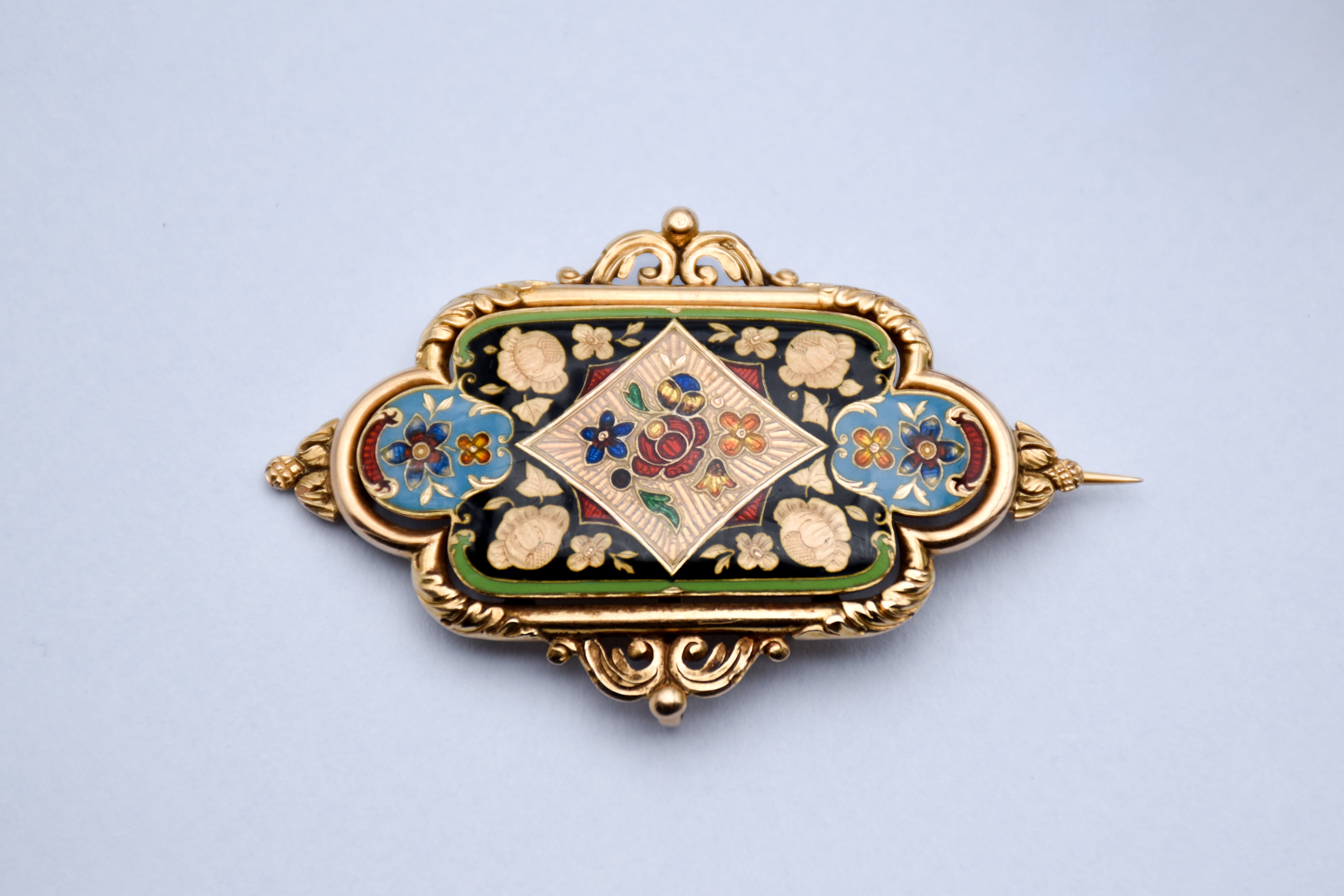 Gros plan d'une broche pendentif en émail polychrome à décor floral