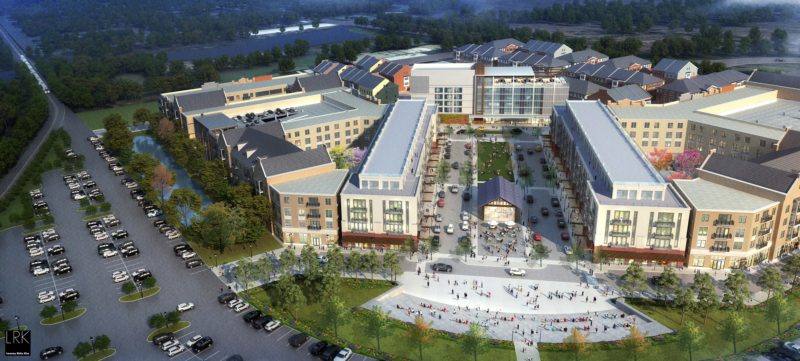 Expansive mixed-use town center development featuring a central public plaza, parking areas, and multiple multi-story buildings protected by M-Fire suppression.
