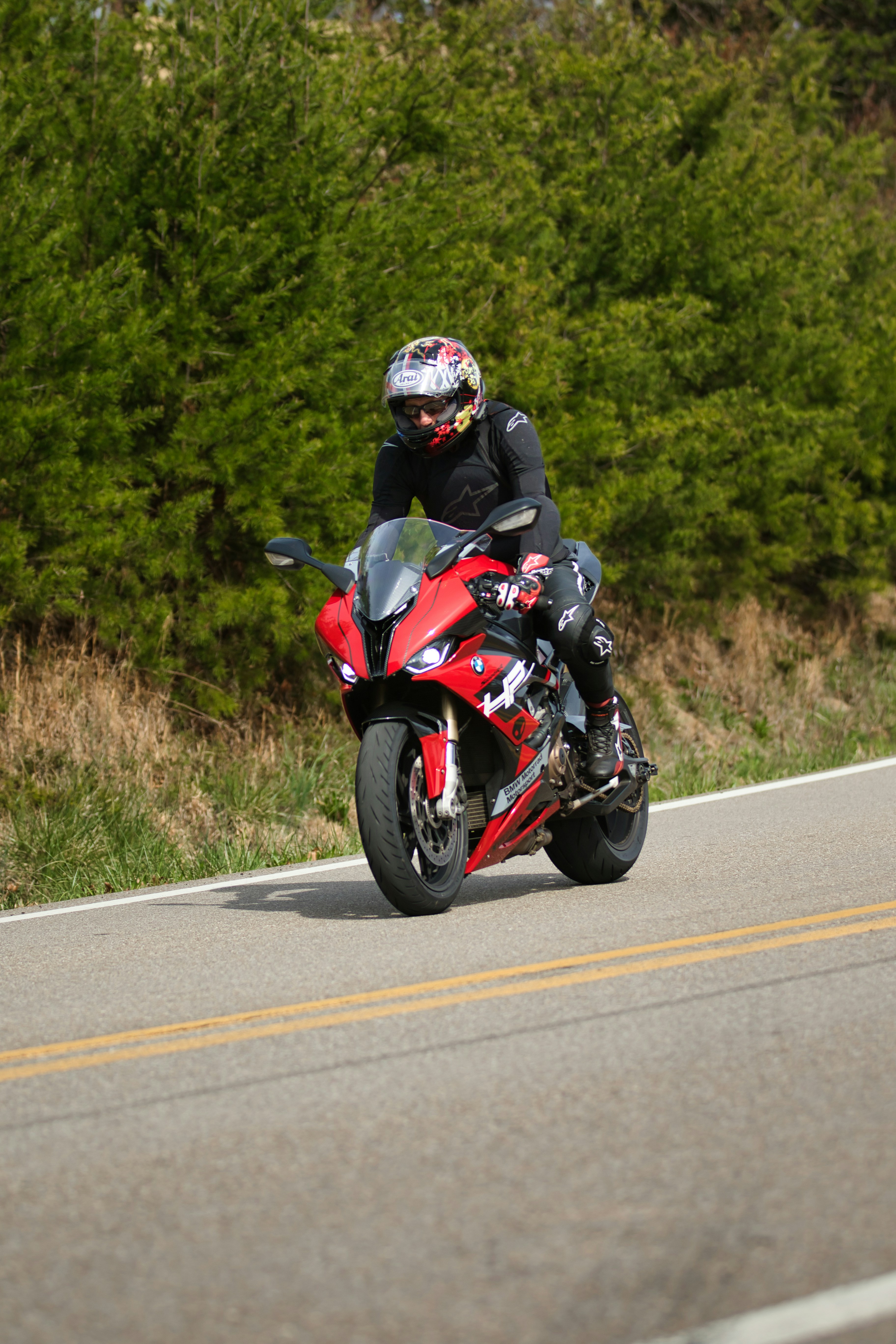 Rider on a red sport motorcycle on a paved road.