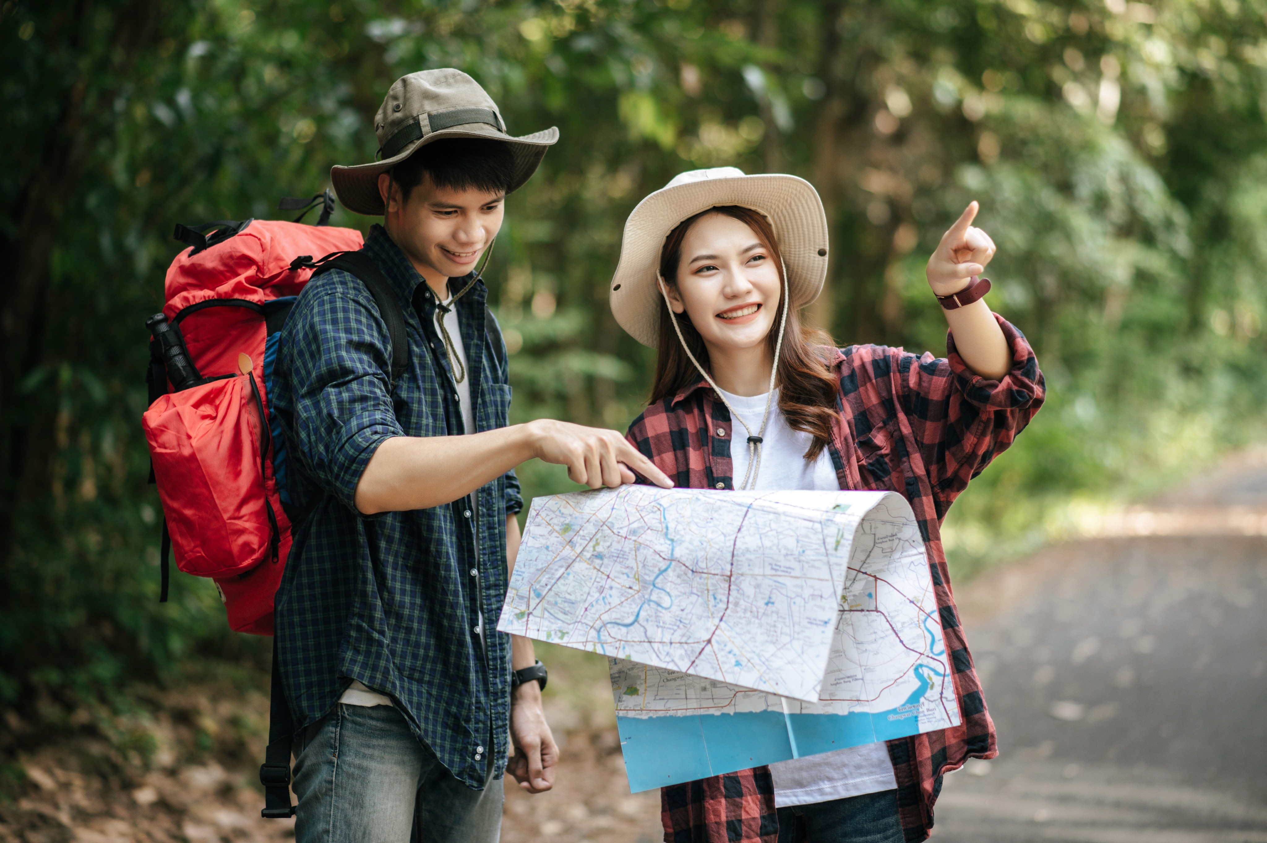 Two hikers in hats reading a map on a forest trail. Like Dislike