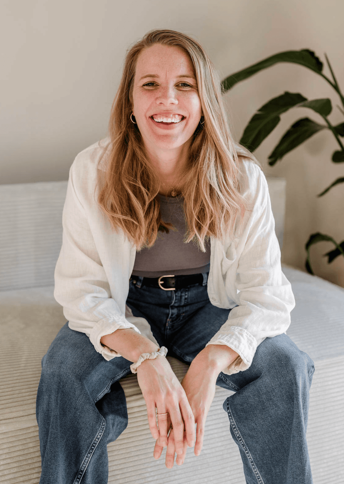 Webdesignerin Melanie von OHNORD studio aus Straubing sitzend auf einer Couch, in die Kamera lächelnd. Ihr Lachen ist offen und freundlich, so wie die Unternehmensphilosophie des Website studios. 