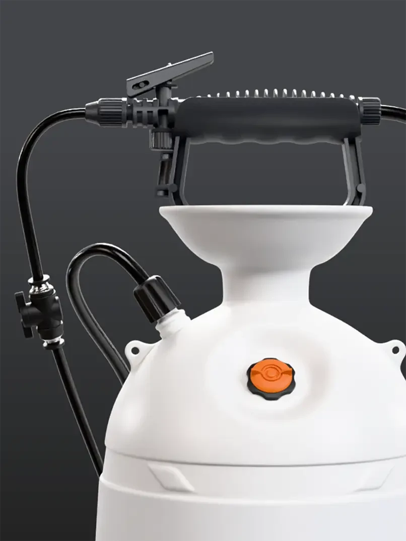 A white garden sprayer with black hose and nozzle against a gray background. It features an orange knob and a large handle on top.