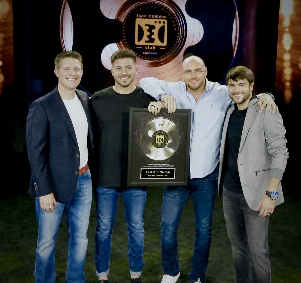 The 7Figure Events team holding the ClickFunnels Two Comma Club award at Funnel Hacking Live