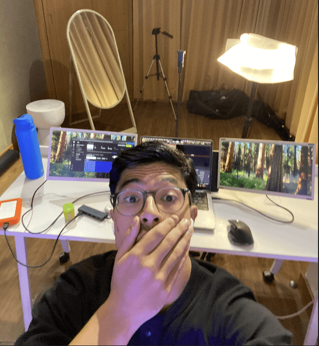 Three individuals gathered around a table, engaged in discussion while examining a laptop.