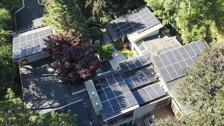Buildings with solar panels, surrounded by greenery. Aerial view.