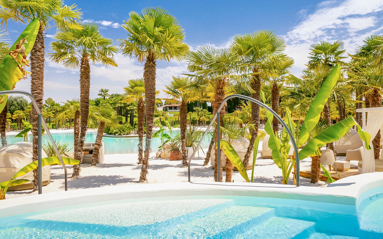 Tickadoo için yerelleştirilmiştir: Palmiye ağaçları ve şezlonglarla çevrili Parco Cavour Su Parkı havuzu.