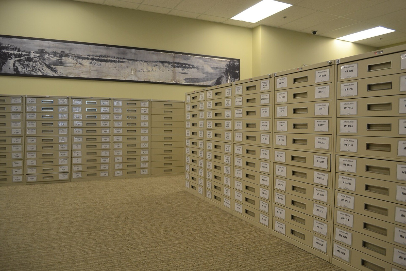 Rows of labelled archive drawers holding paper records.