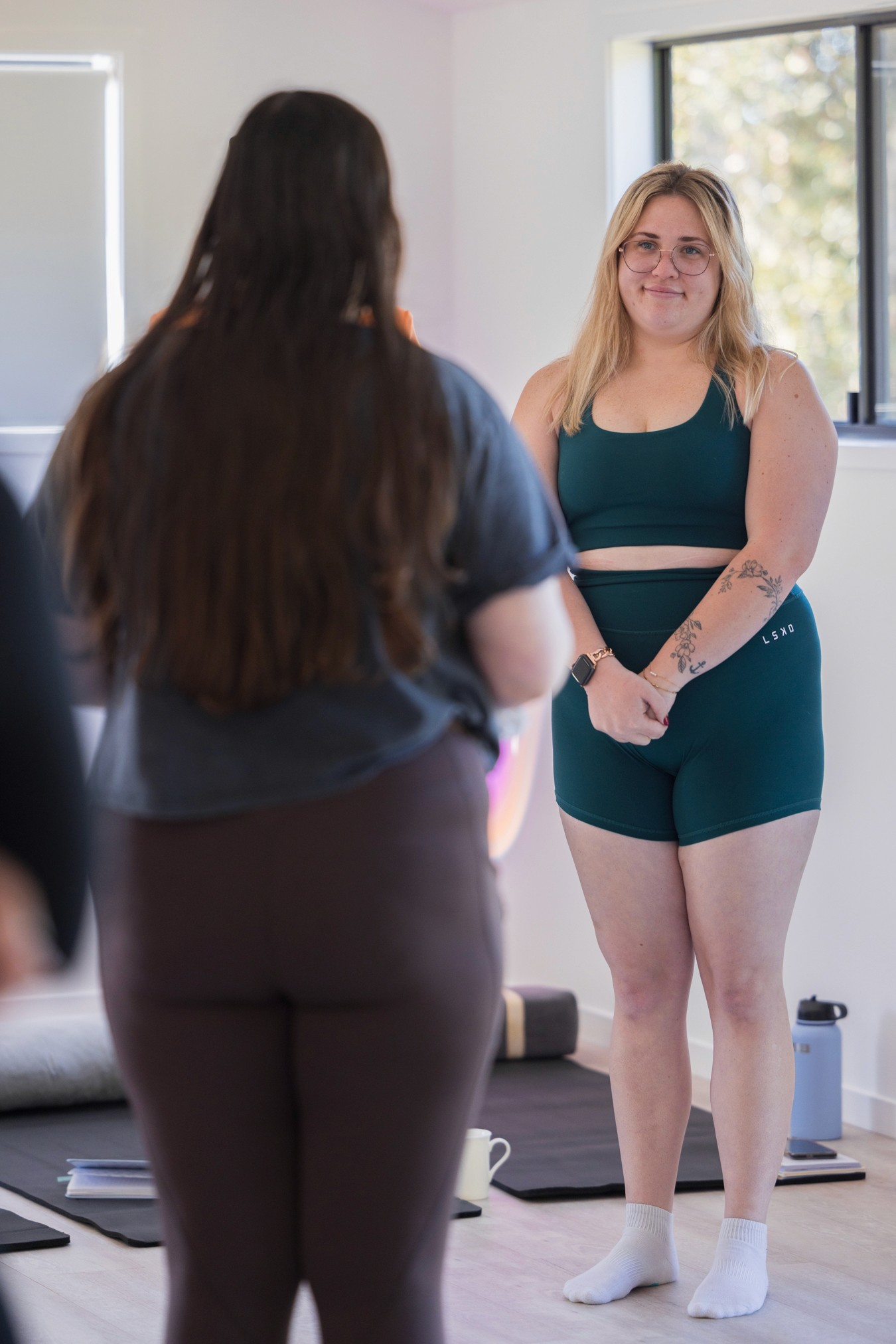 Two women standing and smiling at one another