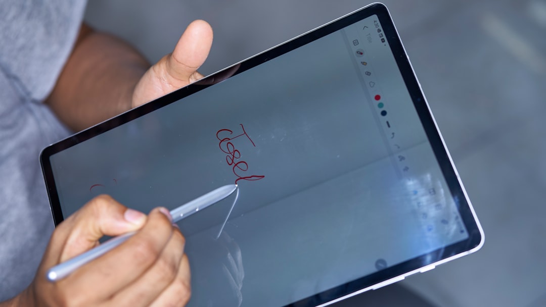 of a powerful and modern logo design being sketched on a tablet - our branding and graphic design services (flyers, print media, logos, etc)