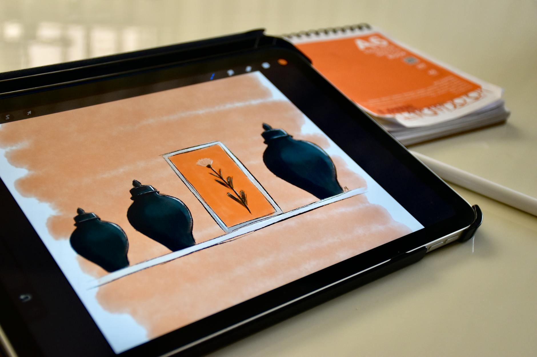 A student uses a stylus and tablet to create digital art and graphic designs in a bright media lab.