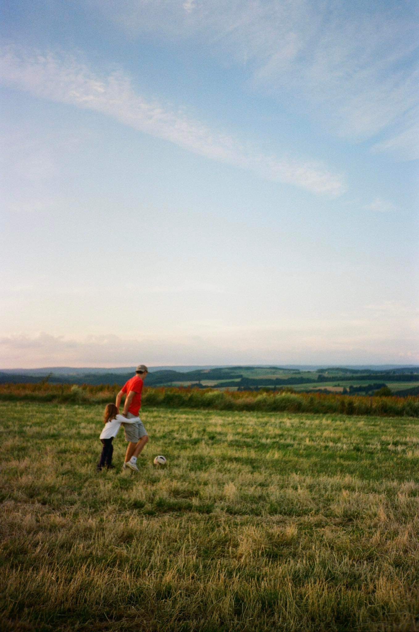 Green car under neon lights in a rainy city street