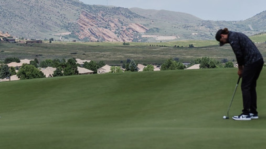 Jax preparing to putt the ball on a green.