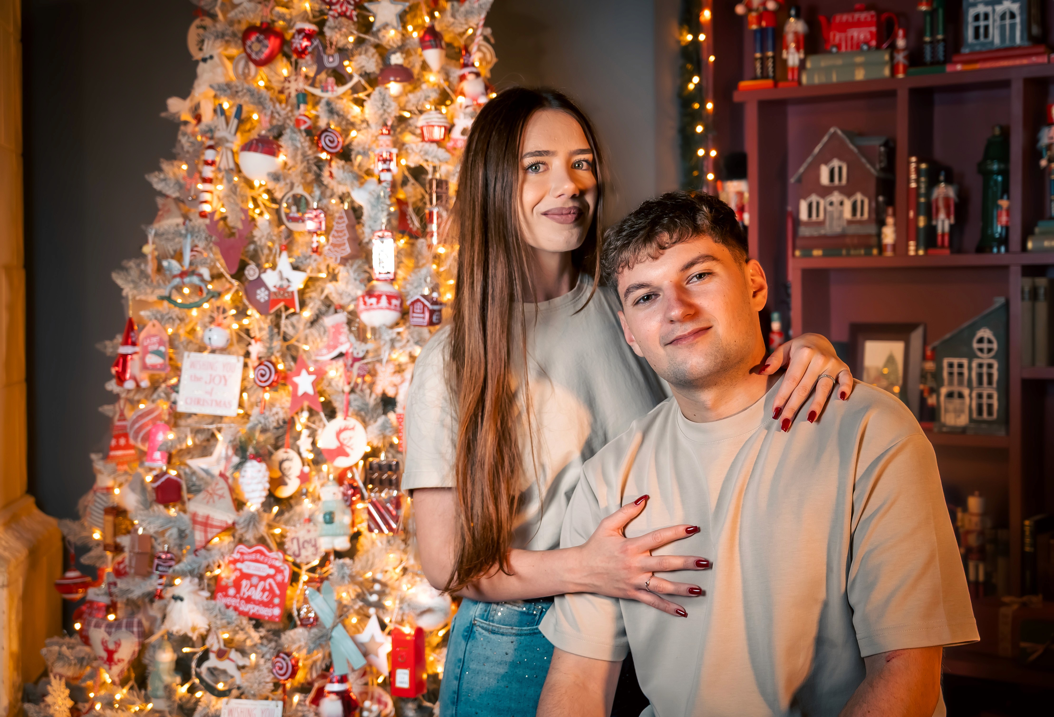 Cuplu fotografiat de Crăciun lângă brad decorat, portret natural cu atmosferă de sărbătoare, fotograf Crăciun București.