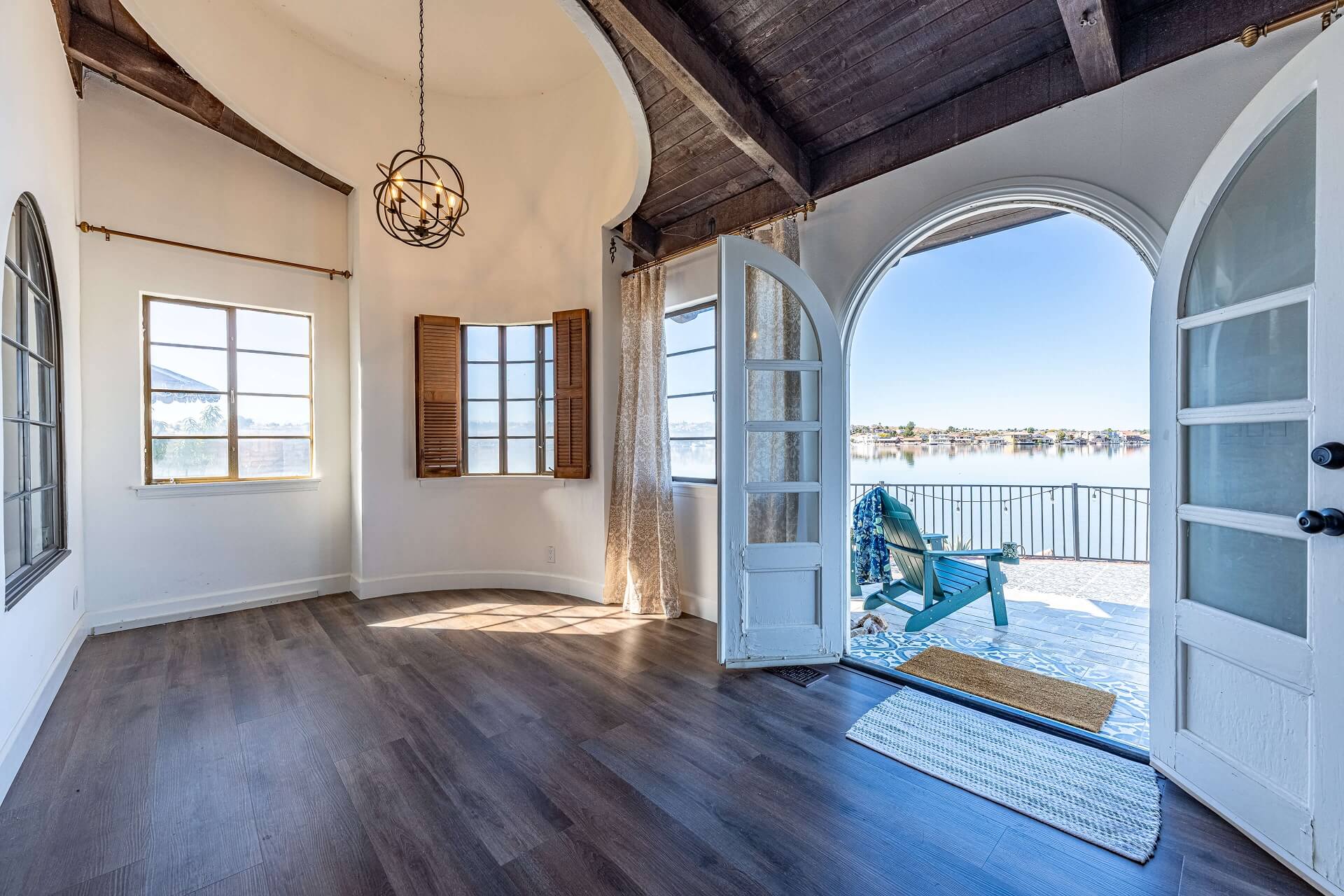 Different camera angle of an arched doorway leading to a backyard patio, with more of the living room interior visible.