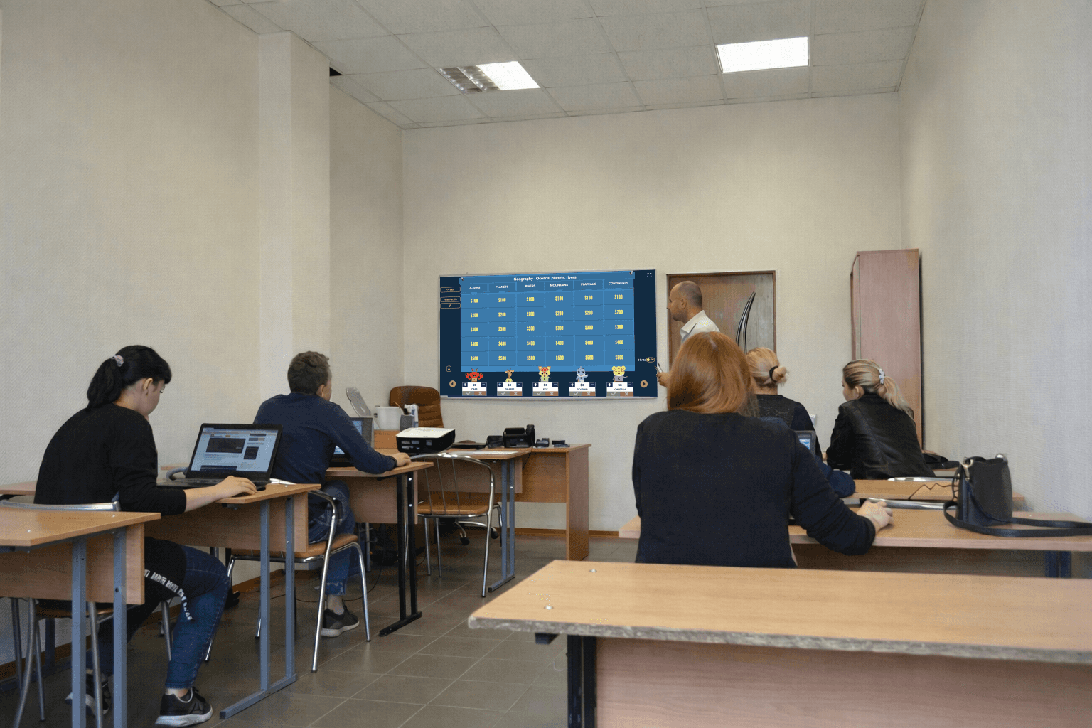 Classroom of students and teacher using Factile to play a Jeopardy-style review game on a shared screen.