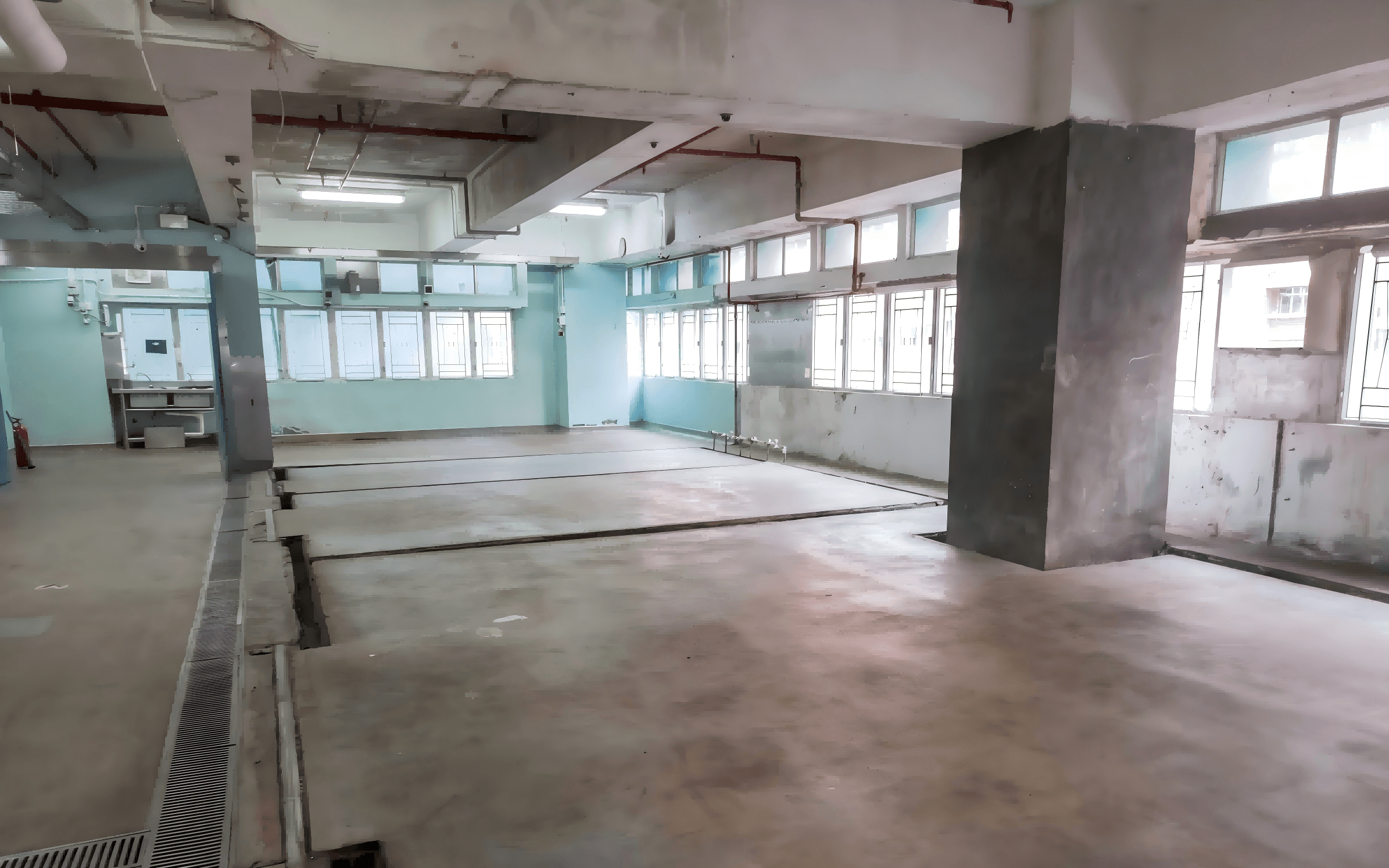 葵匯工業大廈改造前食品廠房現場(老舊開放式生產區,磚砌批盪牆身與水泥地面,未設空氣過濾與受控出入口,未符合食環署衛生要求)