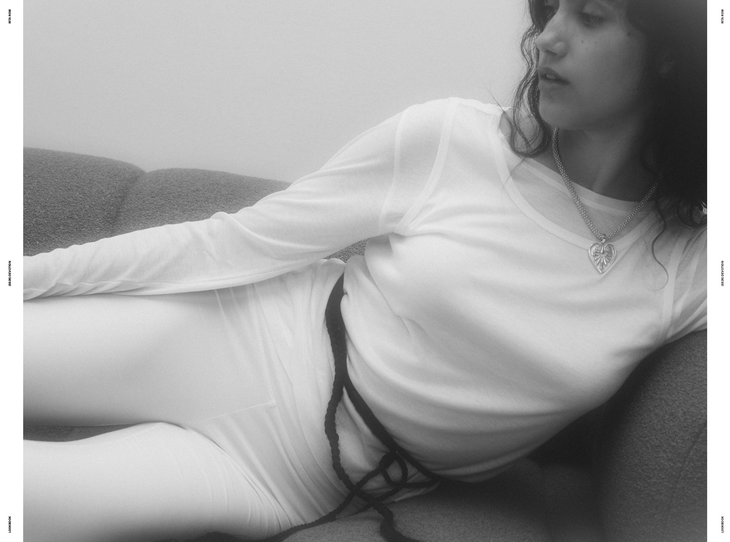 Femme allangui sur un canapé en total look blanc et pendentif en coeur, Rita Row ss26