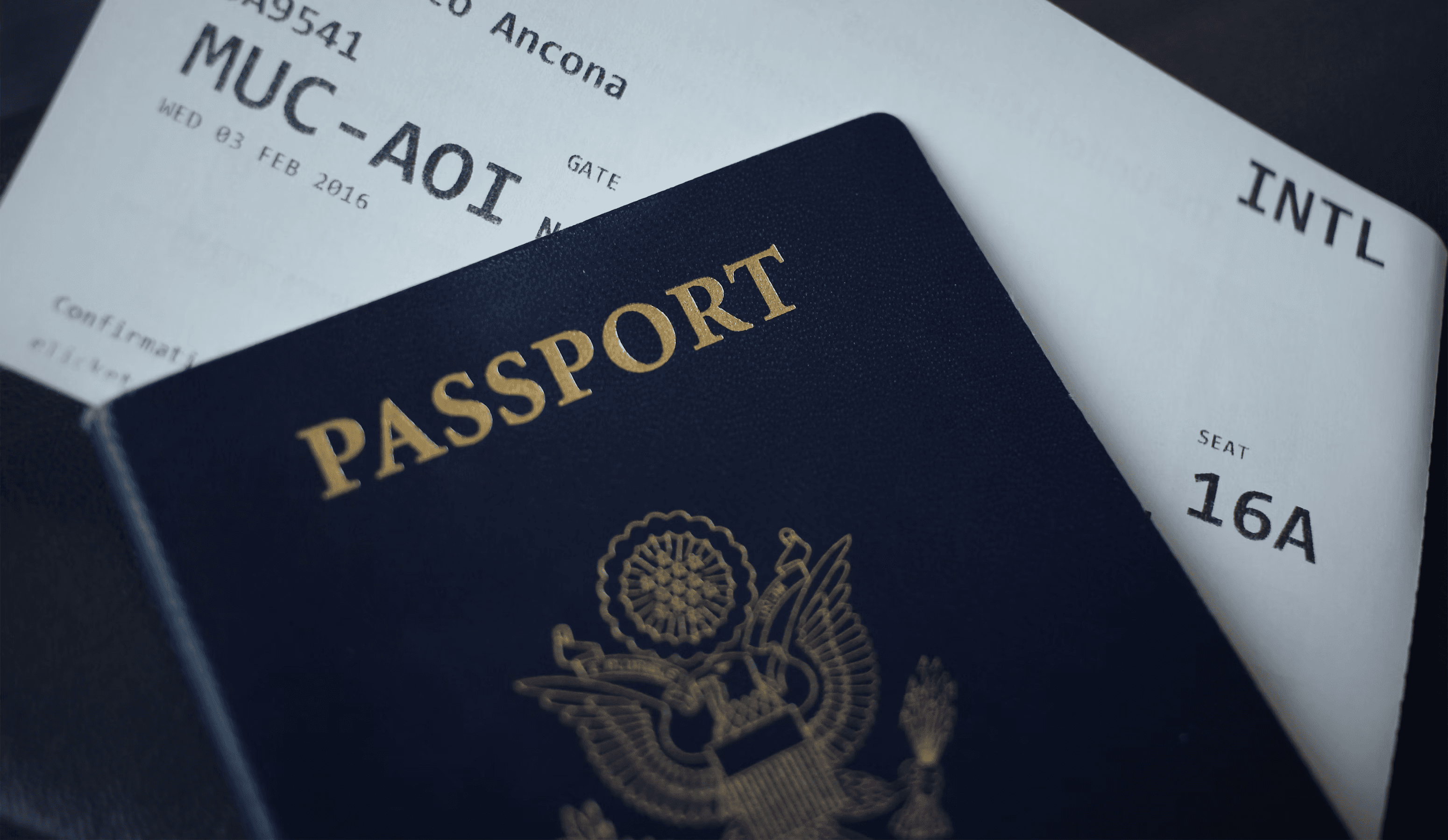 Image of an American passport on top of a plane boarding pass.