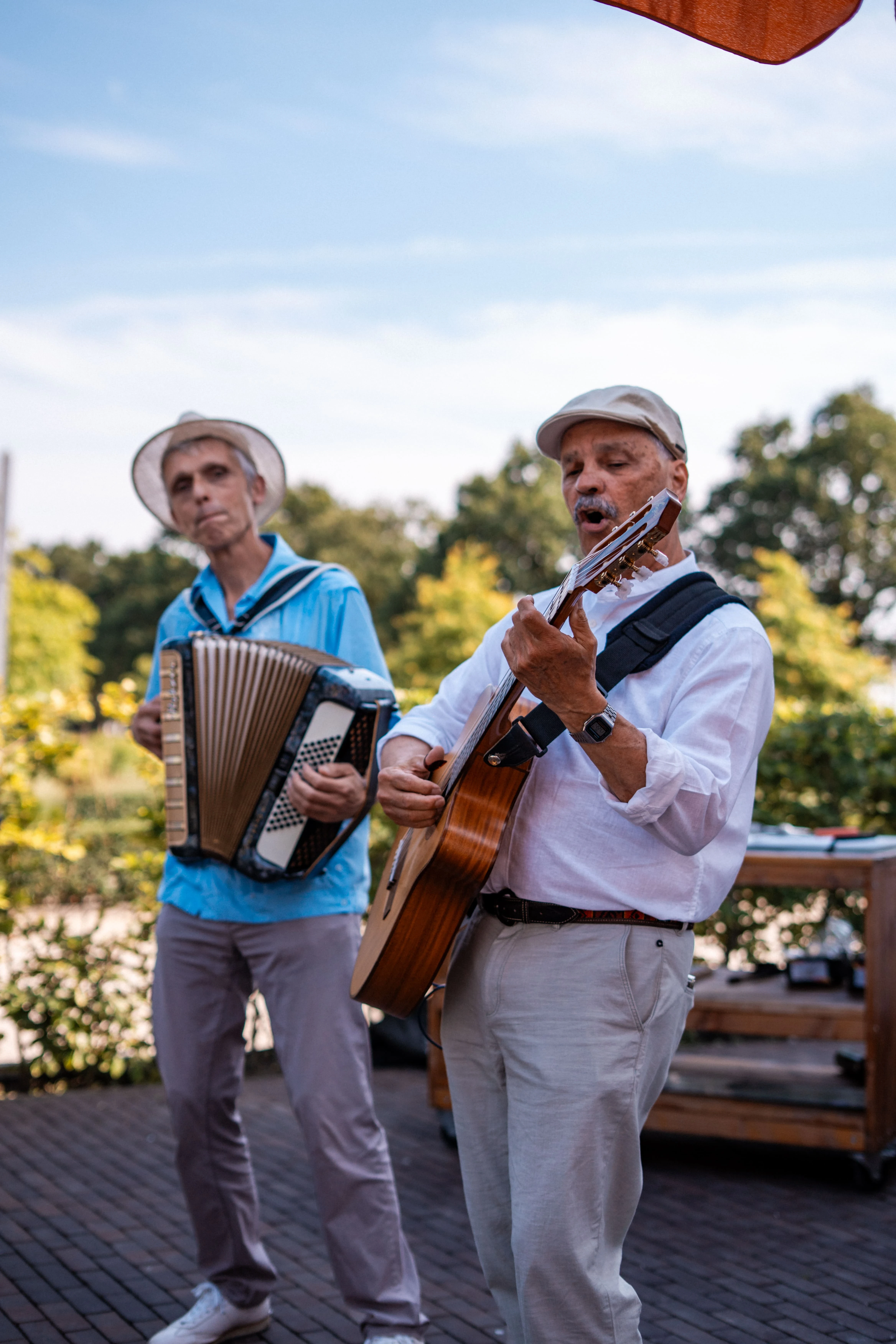 Twee muzikanten spelen accordeon en gitaar op het terras