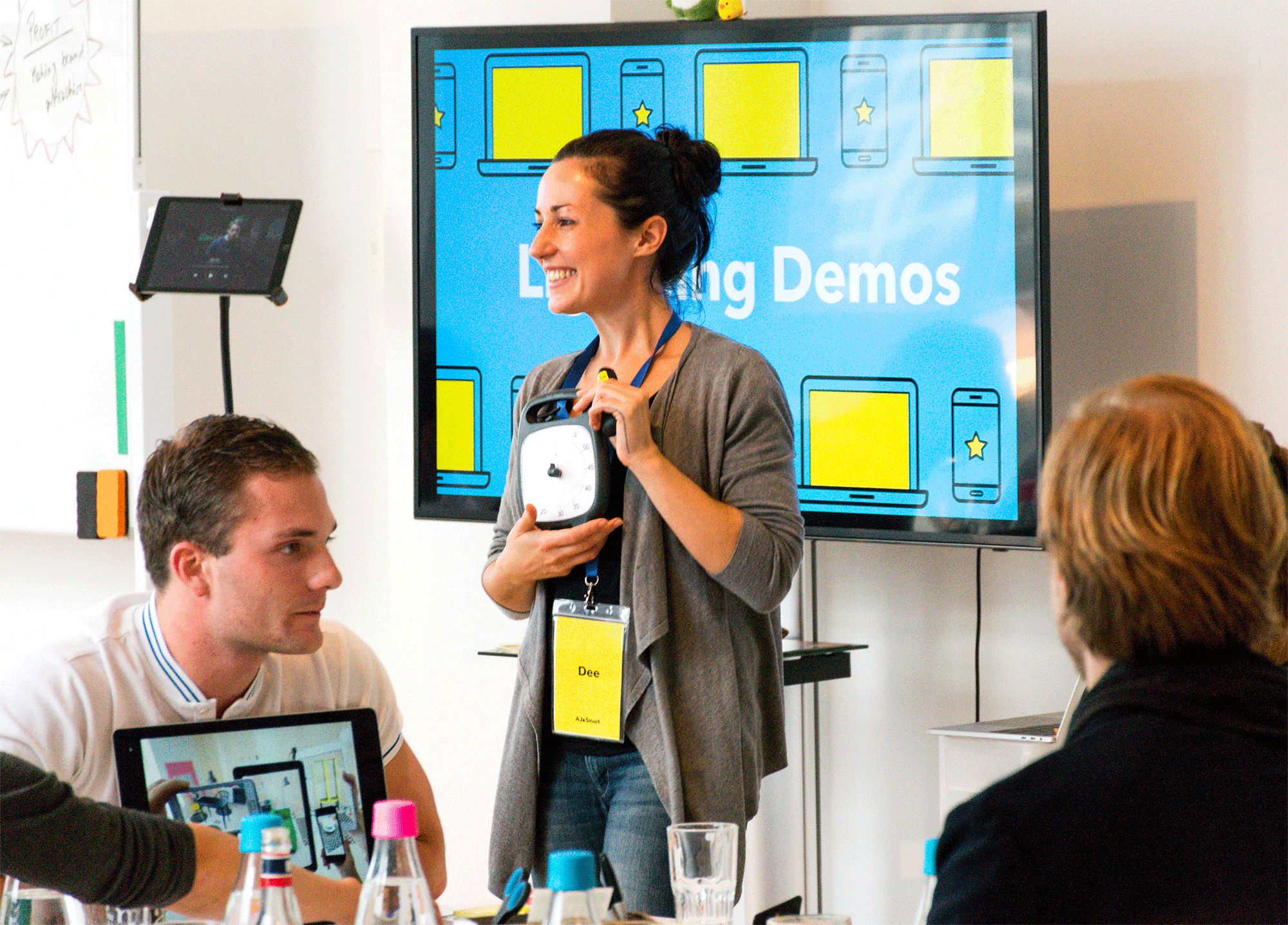 Facilitator presenting prototype demos on a screen to workshop participants with laptops