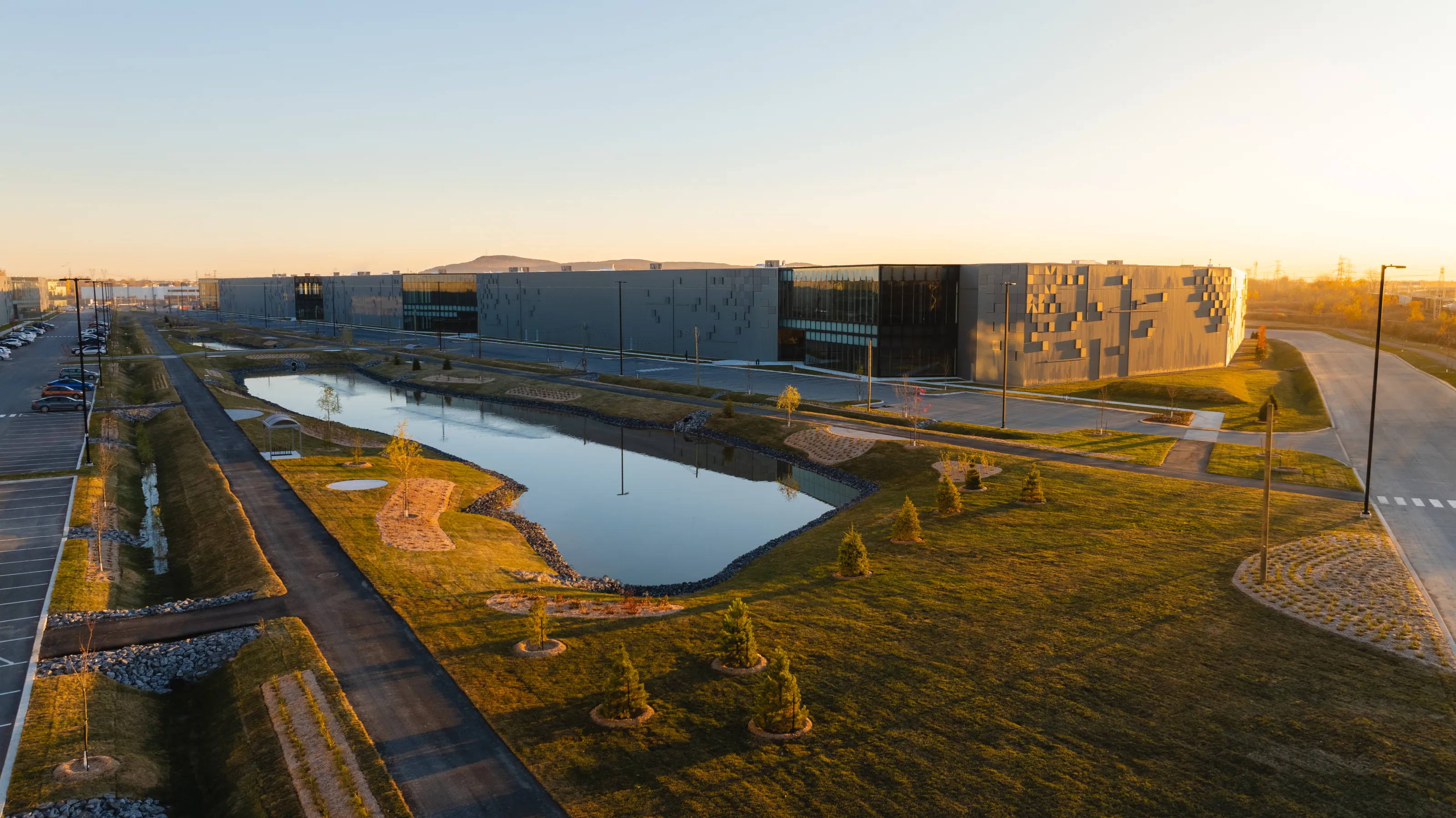 Modern building with green space featuring a lake in the center
