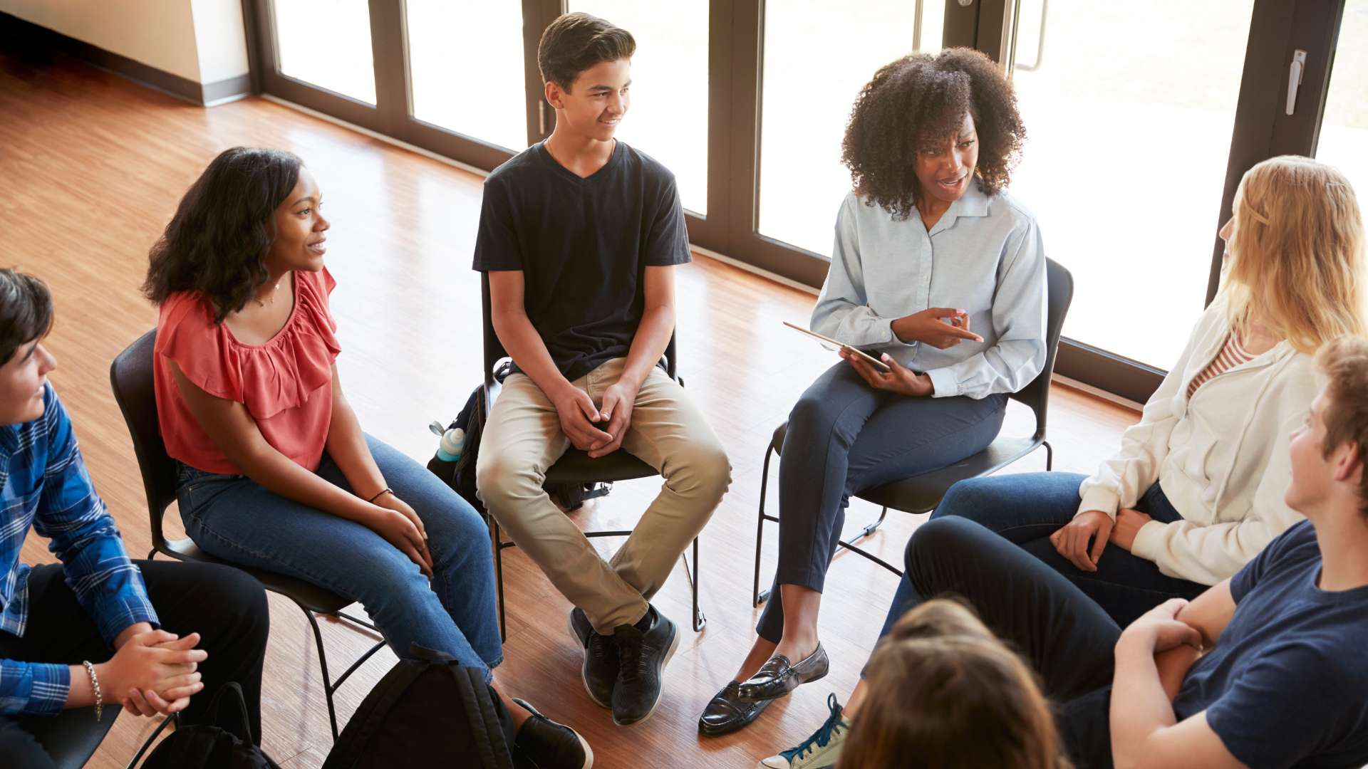 Man laughing while holding credit card and tablet.