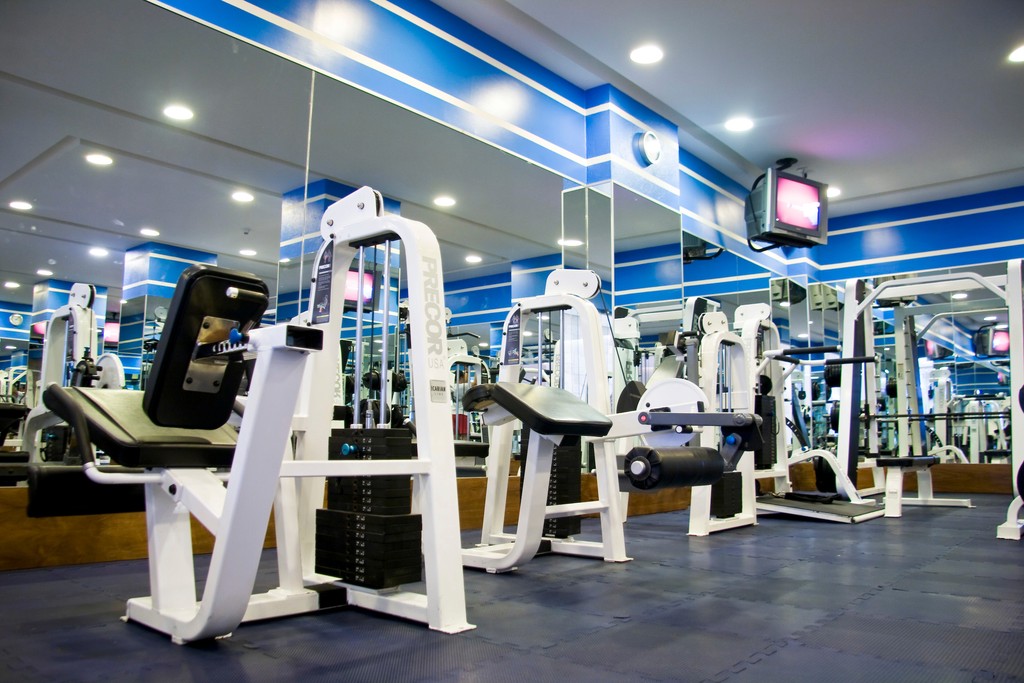 Couple standing on a balcony with binoculars in hand looking out over the ocean