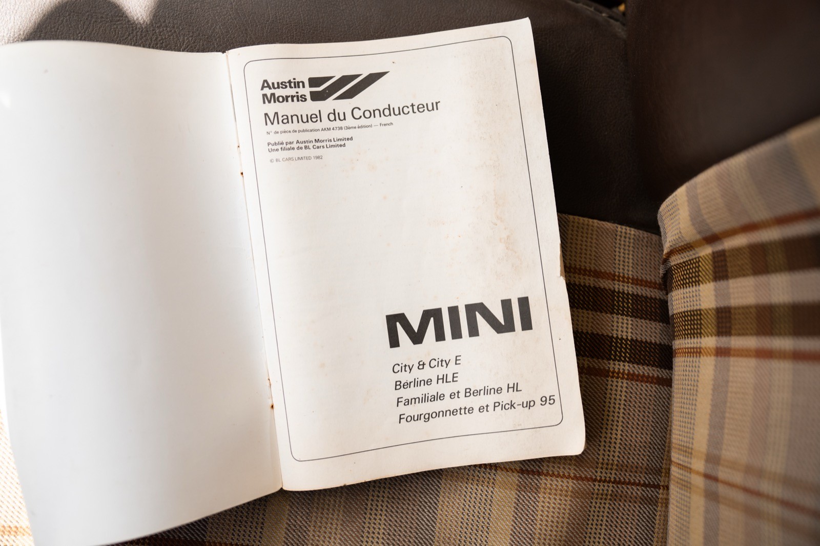 An open book on a table displaying printed text and a logo, with a patterned surface underneath.