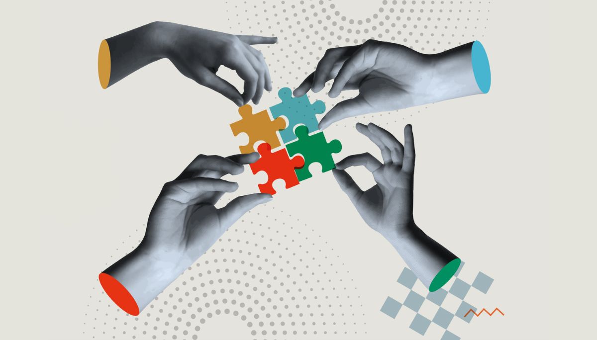 Four hands connecting colorful puzzle pieces, symbolizing interpersonal skills examples.