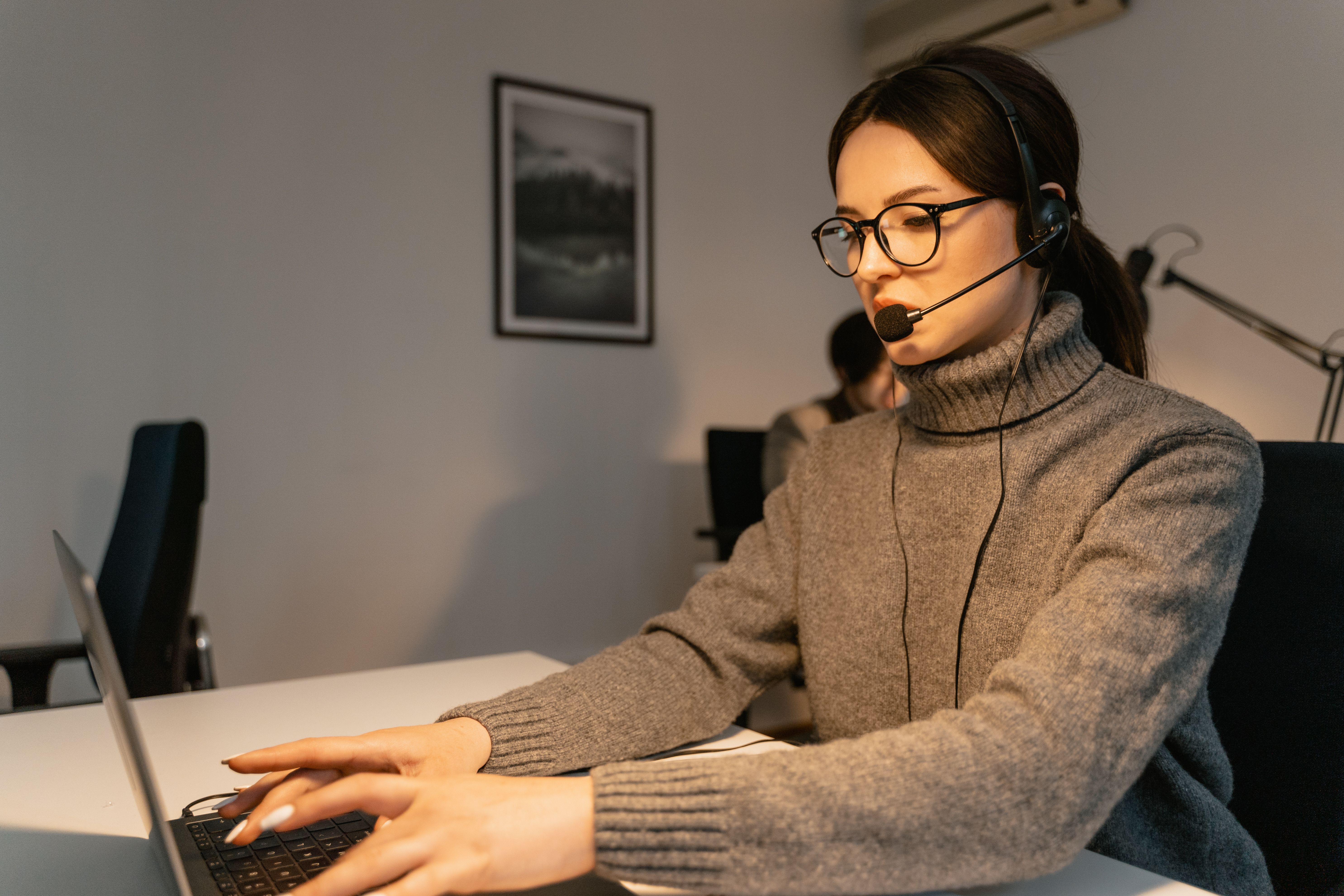 woman in black headphones holding black and silver headphones