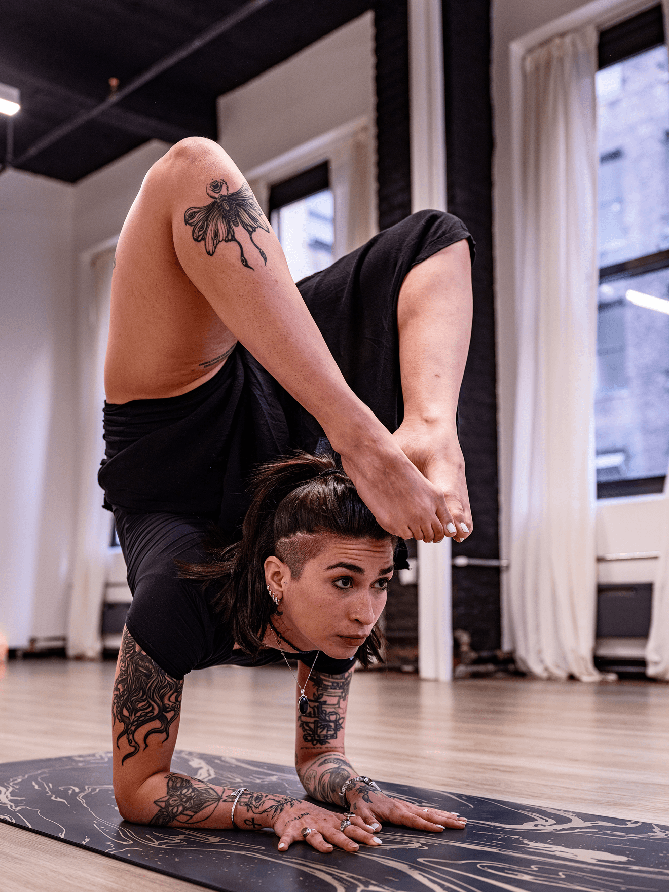 Yoga student practicing an advanced arm balance at Indigo Tribe.