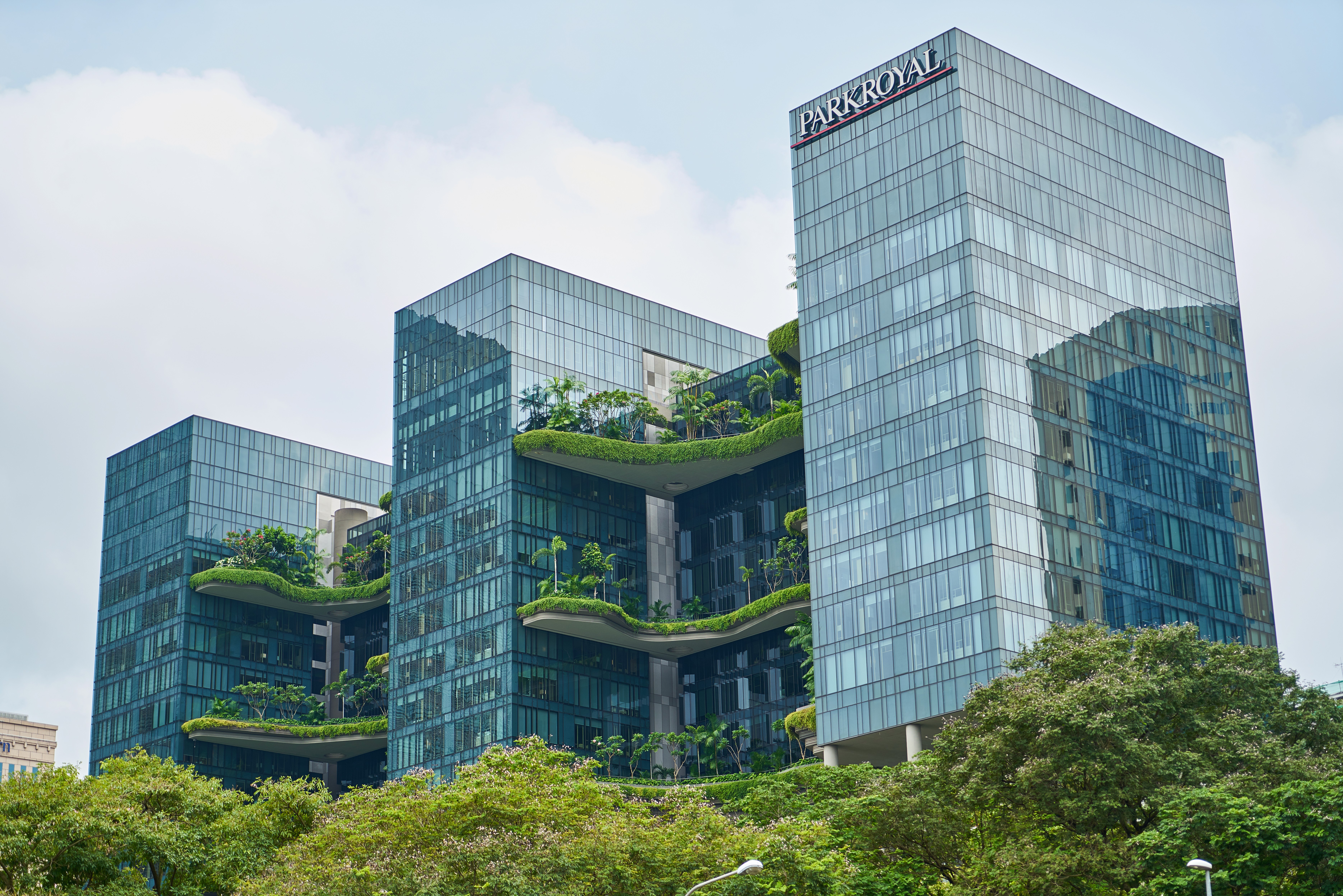 A huge building with 3 blocks and a lot of greenery