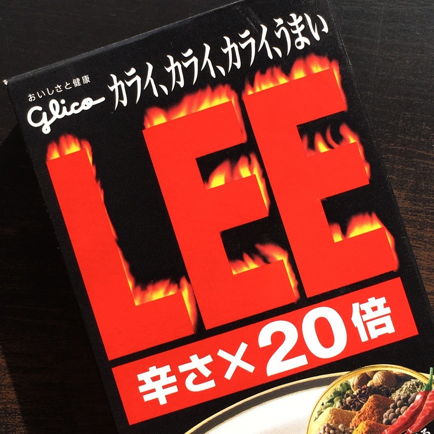 A green butterfly rests on a flower.