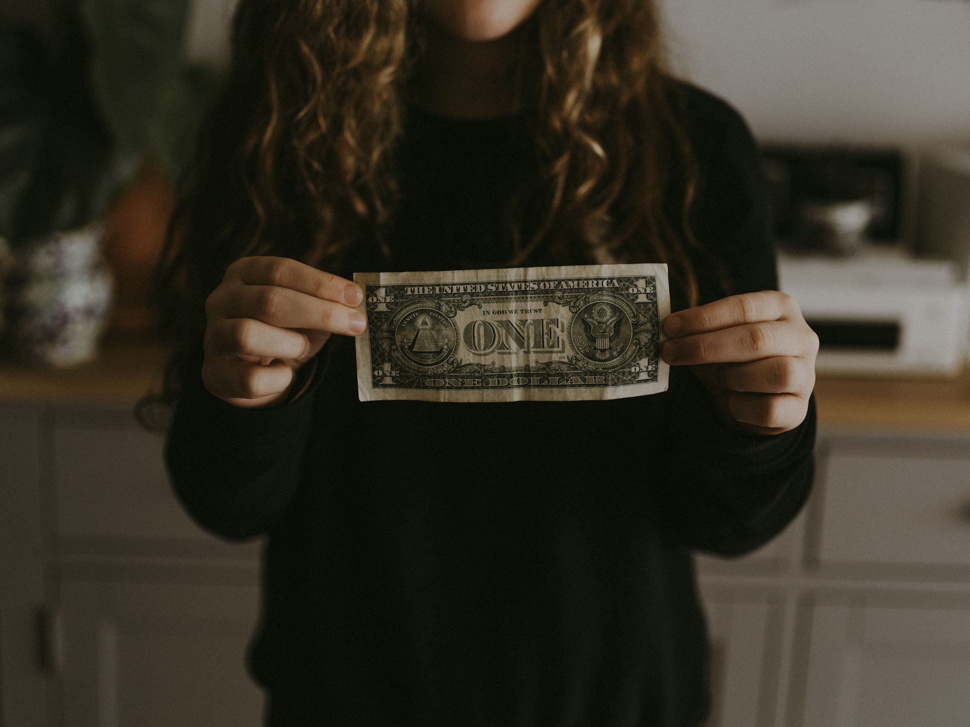 Person holding a one dollar bill