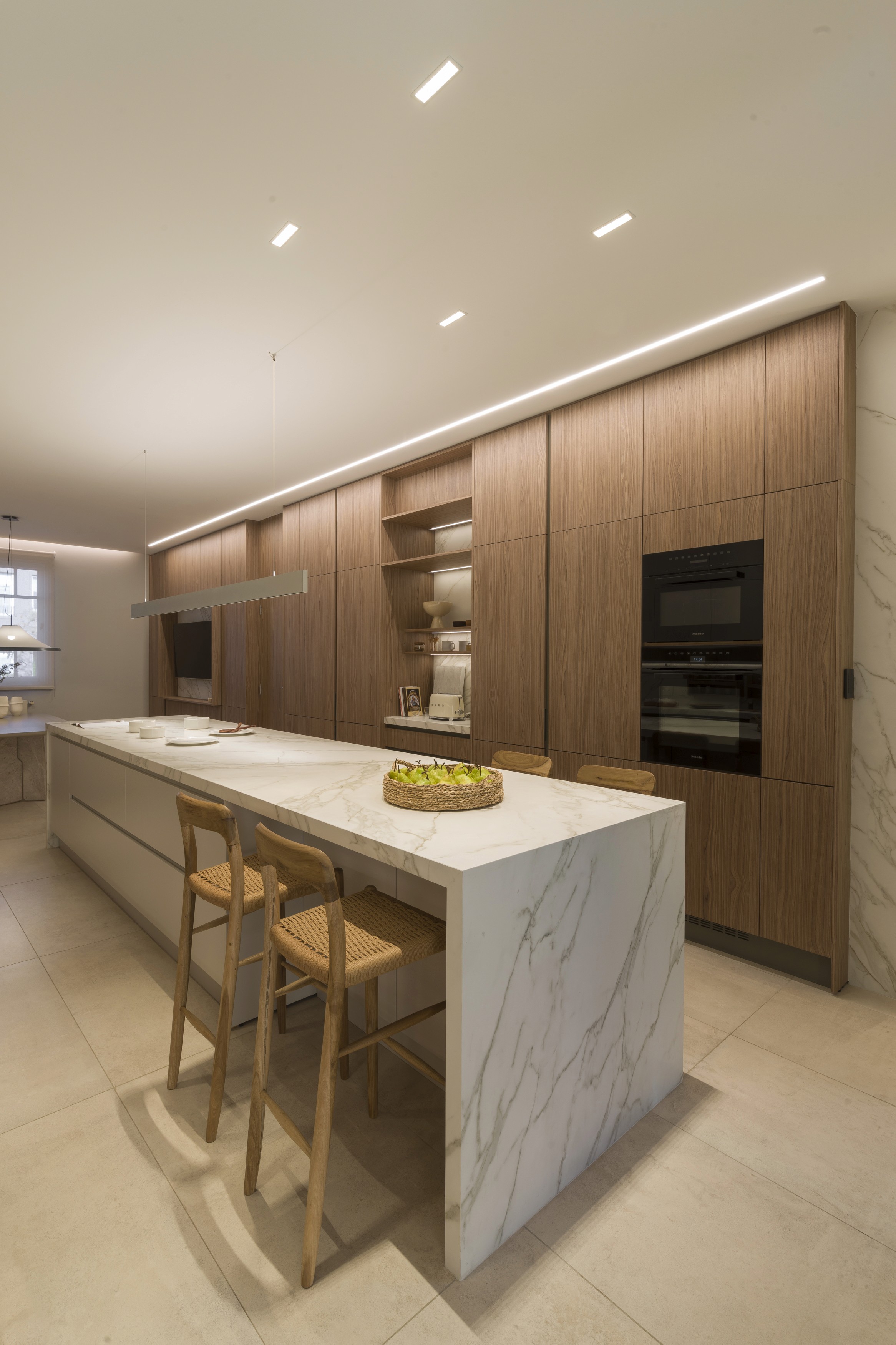 Minimal beige canvas tote bag with sturdy handles and a small leather tag on a light gray studio background.