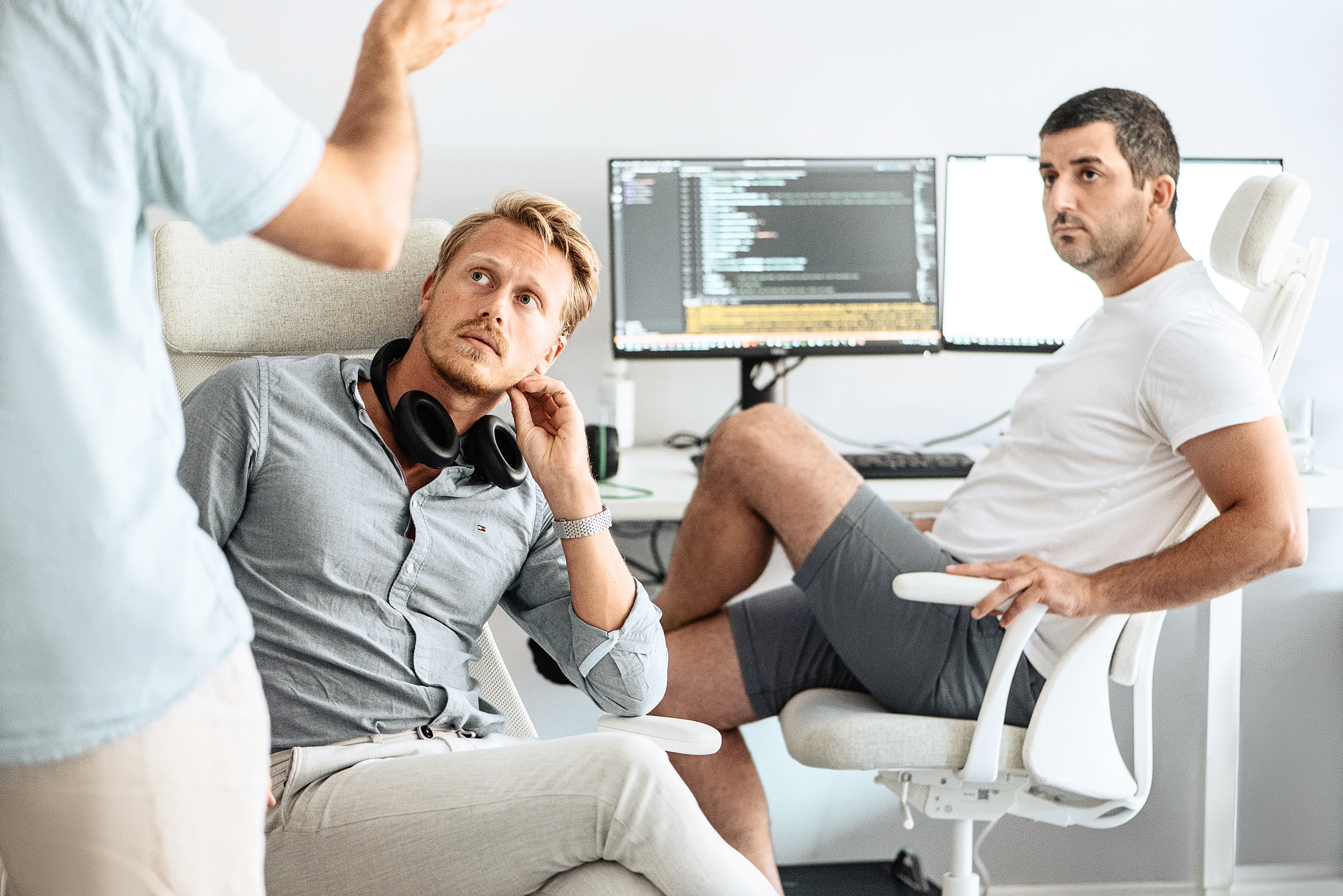 Auxality team discussion during a workday, collaborating in a modern office setting.