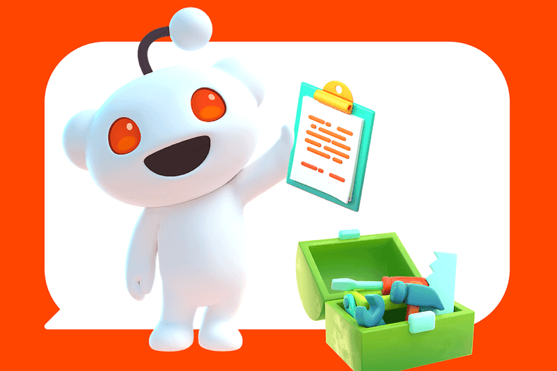 Reddit’s full mascot with an antenna is standing and holding a writing board, while a green box filled with various tools is visible beside it.