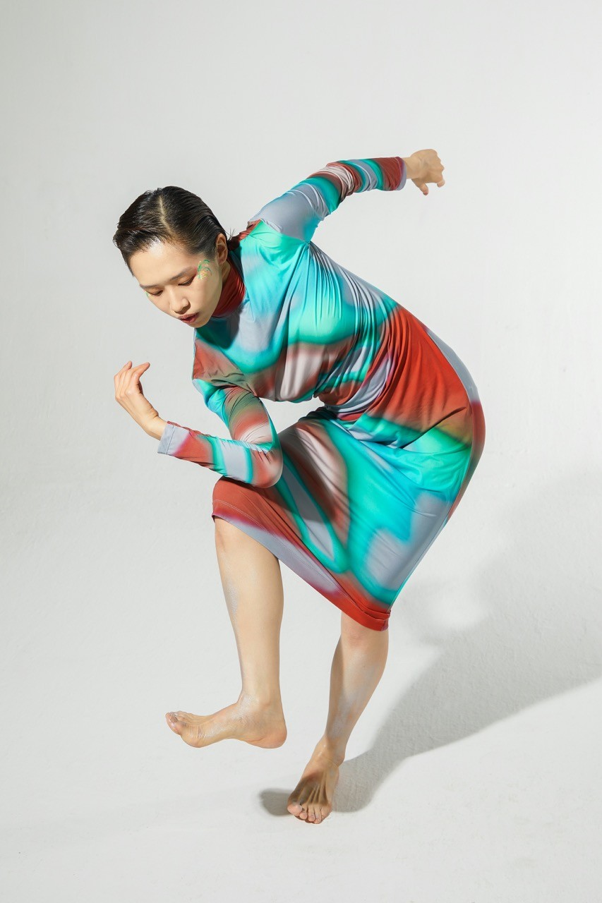 a woman in a colorful dress is dancing