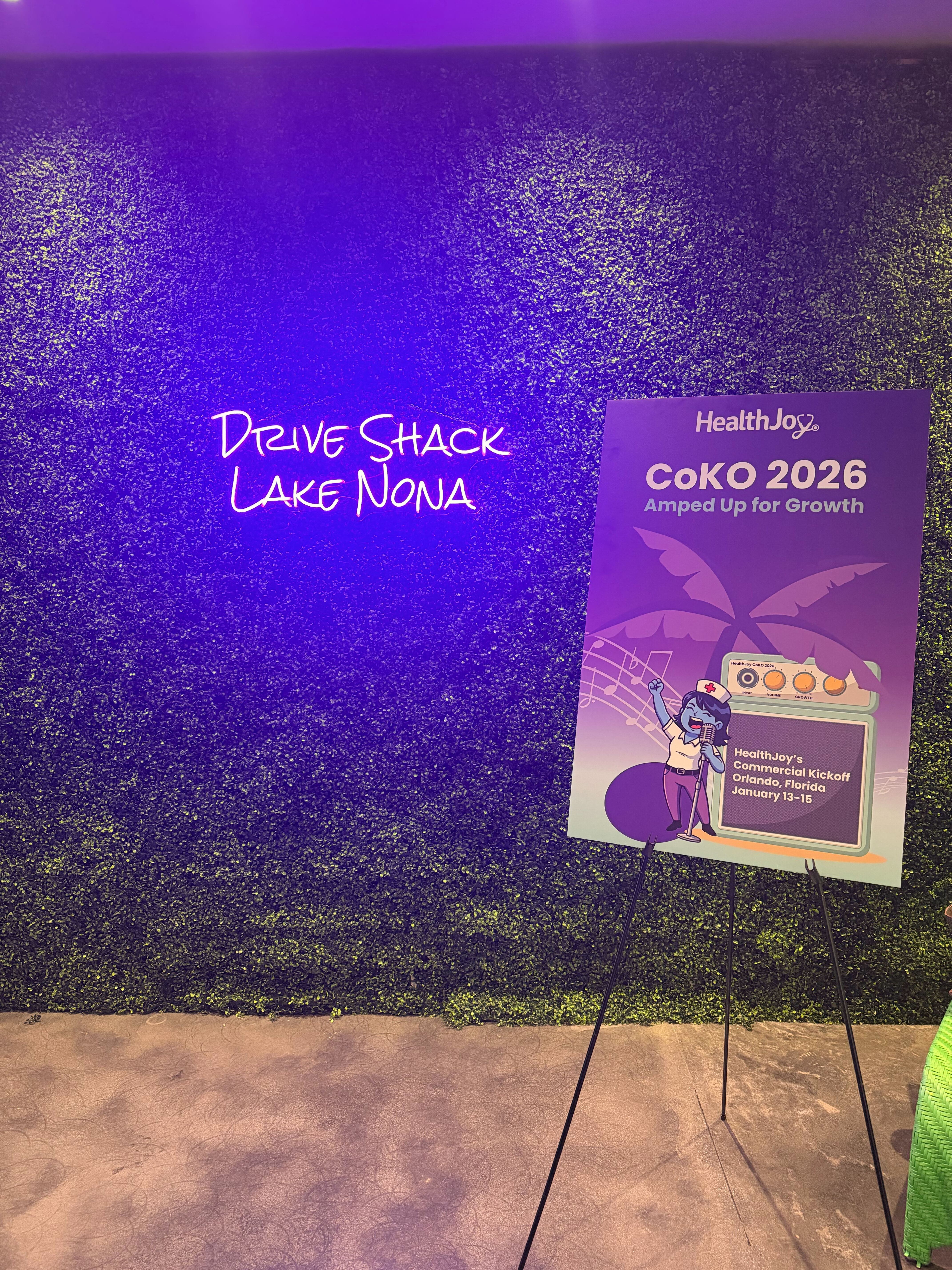 Signage at HealthJoy's CoKO 2026 company kickoff event at Drive Shack Lake Nona — "Amped Up for Growth."
