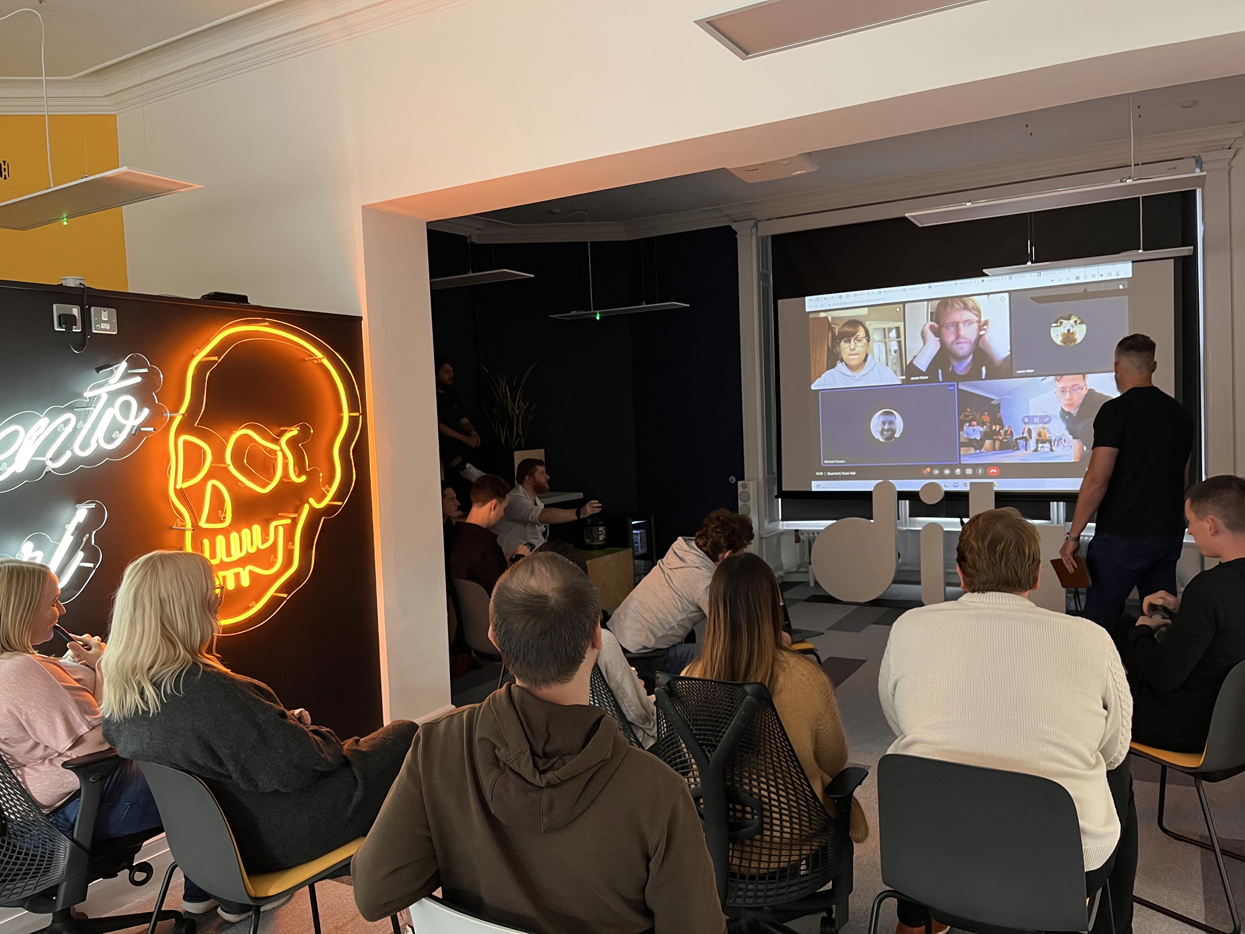 an image of komodo staff attending a town hall meeting and watching a presentation