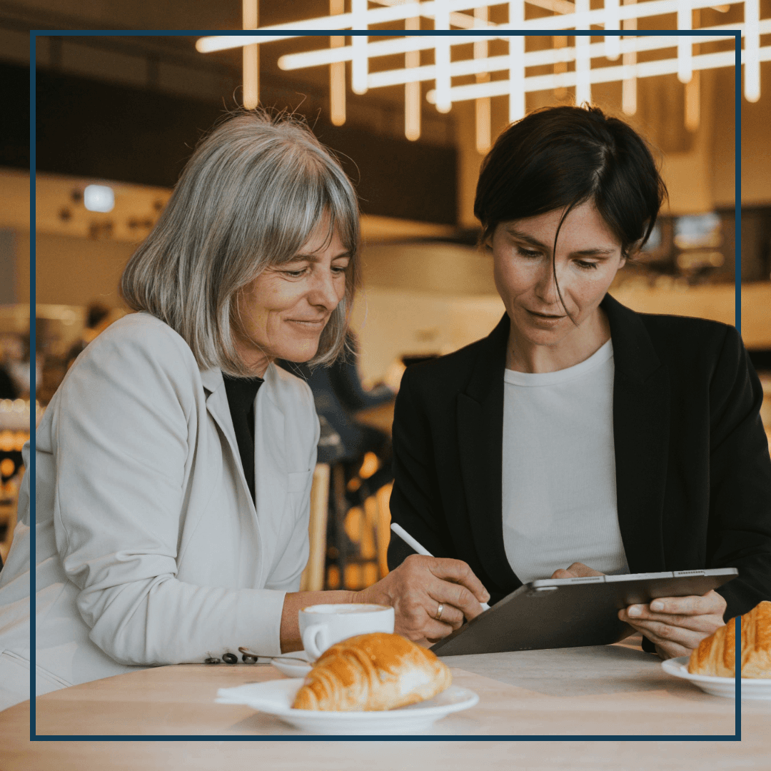 Zwei Frauen schauen im Cafe auf ein Tablet
