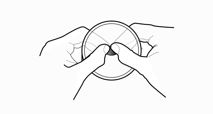 A line drawing of two hands pressing the center of a round device from opposite sides.