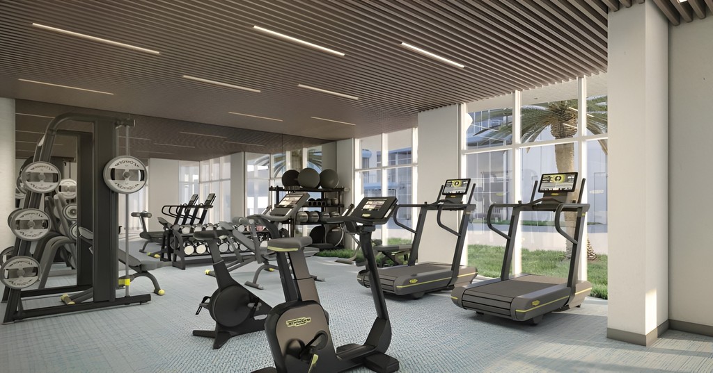 A gym room at Blue Marina Residence featuring treadmills and various exercise equipment for fitness activities.