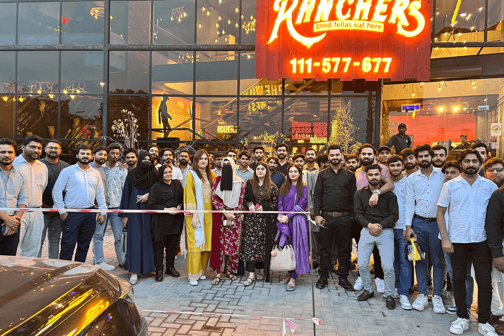 three men sitting while using laptops and watching man beside whiteboard