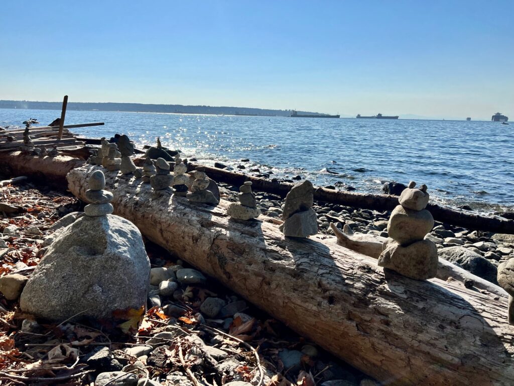 Some stone formations along the seawall walk in Vancouver, Canada. there a few ships in the water at a distance.