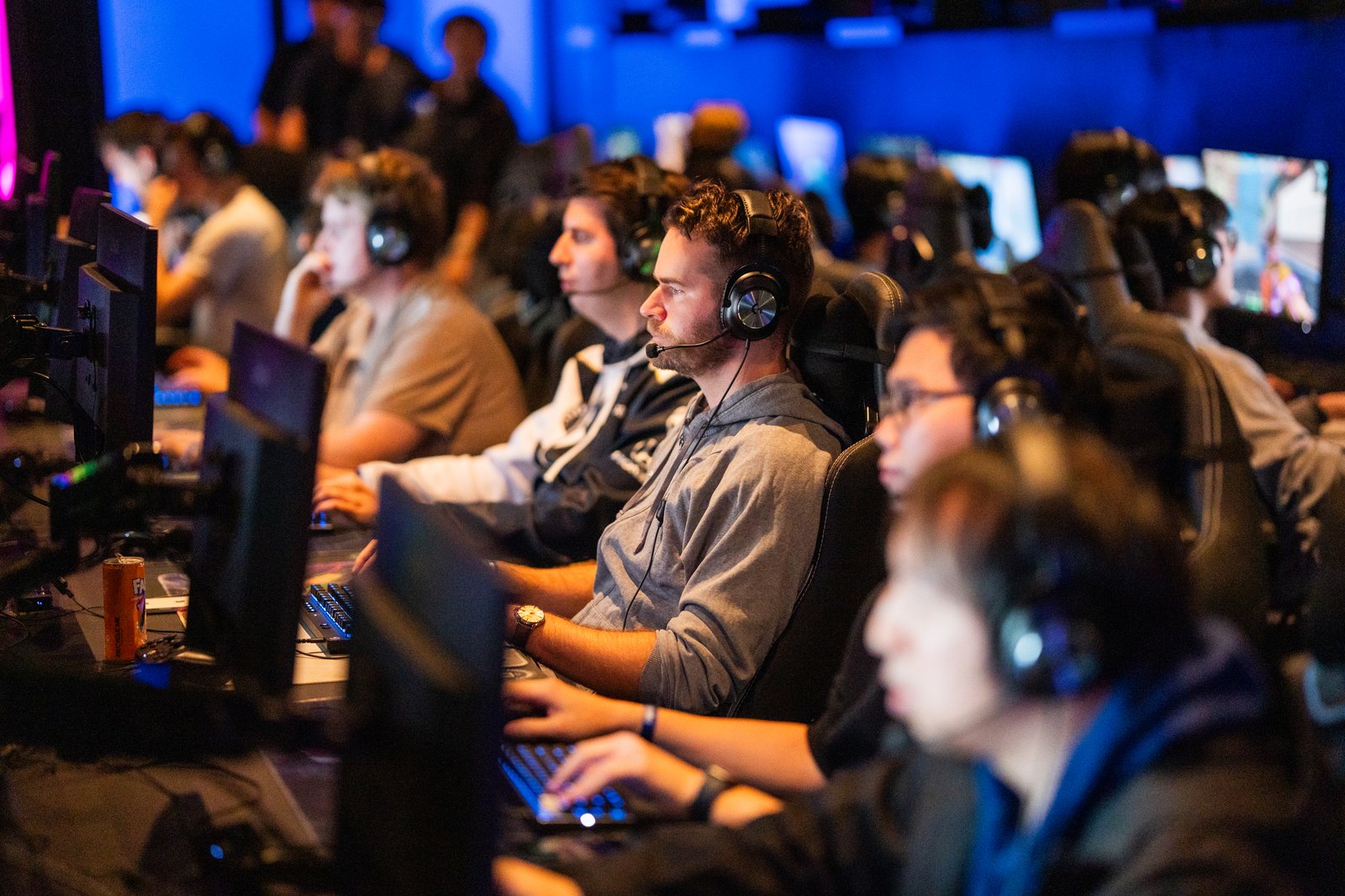 Group of gamers in headsets playing at a row of PCs in the Fortress Legion Lounge
