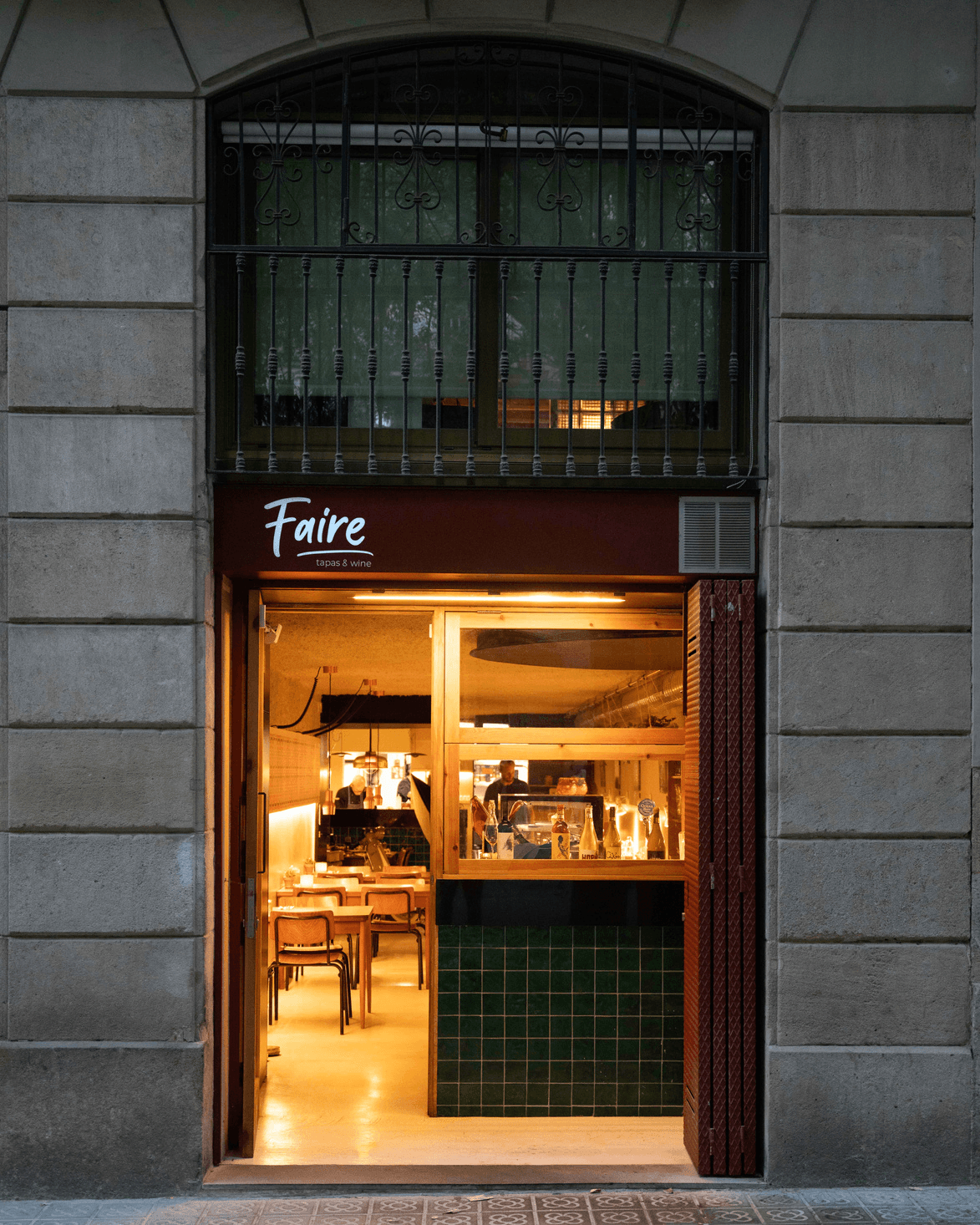 Entrada del restaurante Faire. Tapas & Wine en Carrer de Girona 79, Eixample Barcelona — tapas vegetarianas y vinos naturales en un ambiente cálido de noche