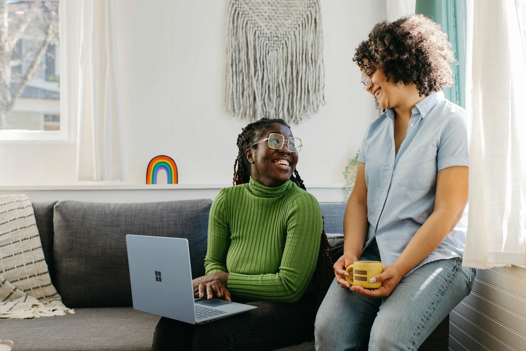A smiling counselor talks with a client on a couch