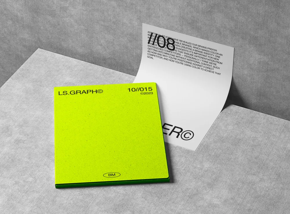 Stationery mockup featuring a neon green notepad with bold black typography and a minimalist design, paired with a partially unfolded white sheet displaying modern text. Set on a textured gray background.
