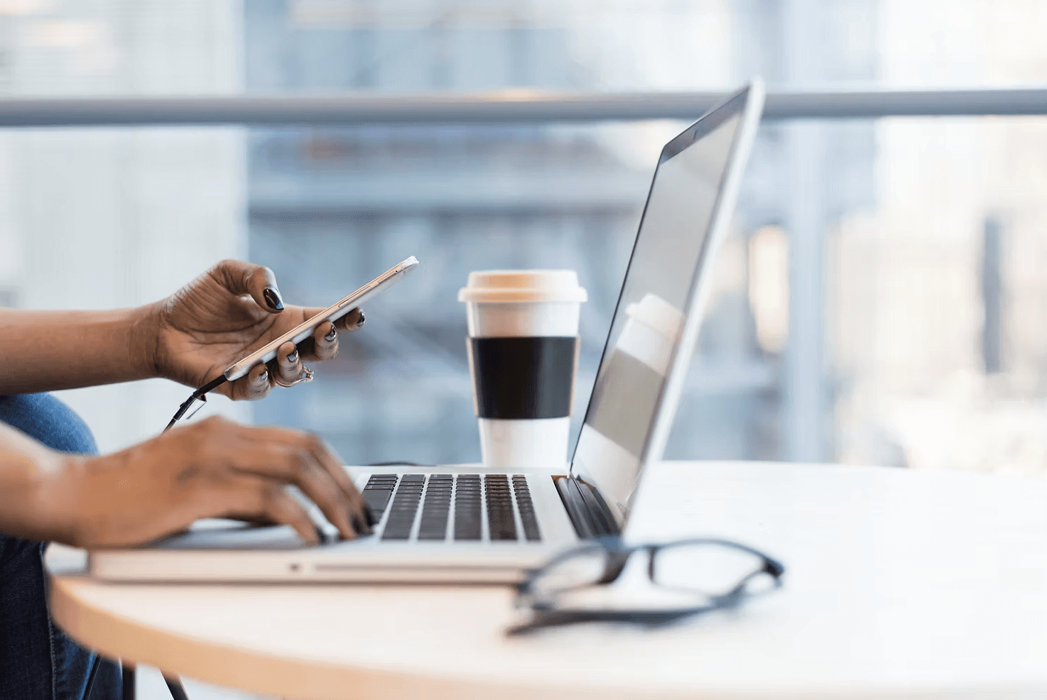 A freelancer working in a cafe uses ai-powered invoicing to optimize her accounting process